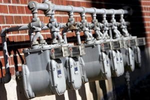 Row of utility meters outside an old brick apartment complex (shallow focus).